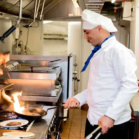 Orchard Heights Chef Created Meals, chef frying a dish.