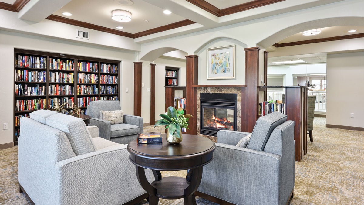 The library at Orchard Heights with shelves of books and comfortable seating