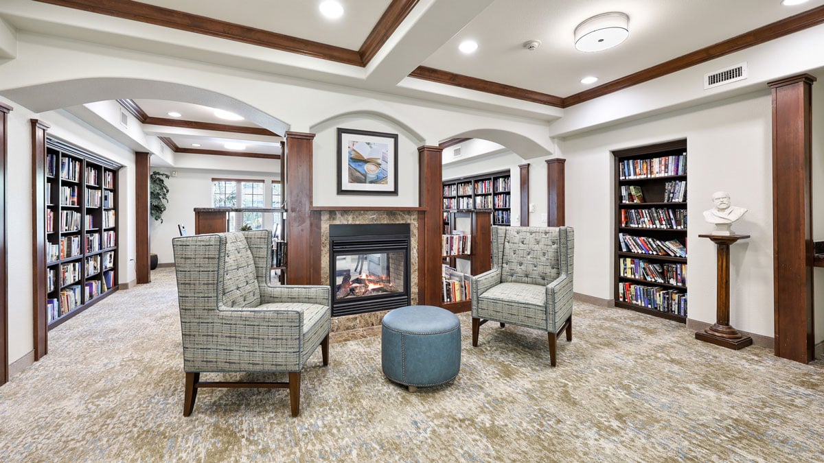 The library at Orchard Heights with shelves of books and comfortable seating